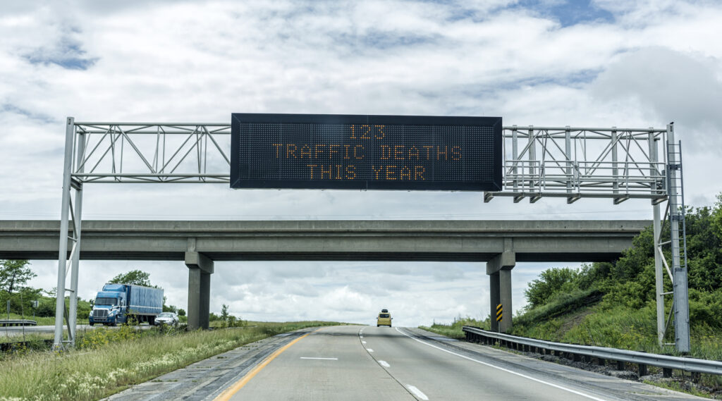 Traffic Deaths sign overhead on highway car crash fatalities