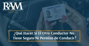 Conductora con el carné de conducir en la mano dentro de un coche: qué hacer si el otro conductor no tiene seguro ni carné de conducir